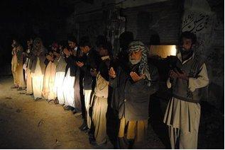 Habitantes de Jafarabad, Pakistán, oran frente a sus viviendas después del terremoto de la madugada del miércoles del 19 de enero.